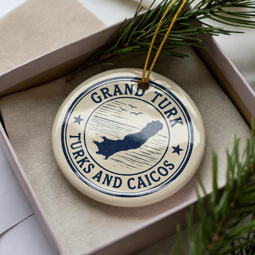 A circular ornament with the text "GRAND TURK TURKS AND CAICOS" printed on it, surrounded by pine branches.