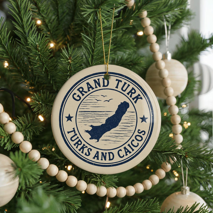 A Christmas tree decorated with ornaments, including a circular ornament with the text "GRAND TURK TURKS AND CAICOS" and a silhouette of a bird.