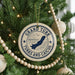A Christmas tree decorated with ornaments, including a circular ornament with the text "GRAND TURK TURKS AND CAICOS" and a silhouette of a bird.