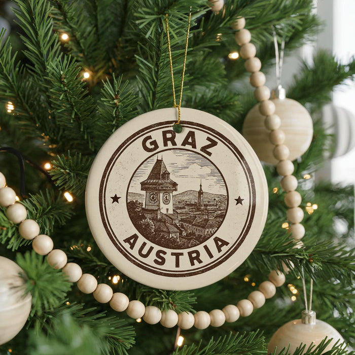A Christmas tree decorated with ornaments, including a circular ornament with the text "GRAZ AUSTRIA" and a picture of a building.