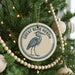 A Christmas tree decorated with ornaments, including a circular ornament with a blue heron design and the text "GREAT BLUE HERON" around the edge.