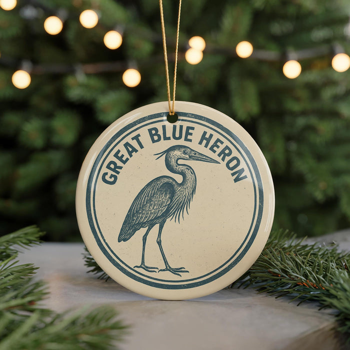 A circular ornament featuring a blue heron, with the text "GREAT BLUE HERON" written around the edge.