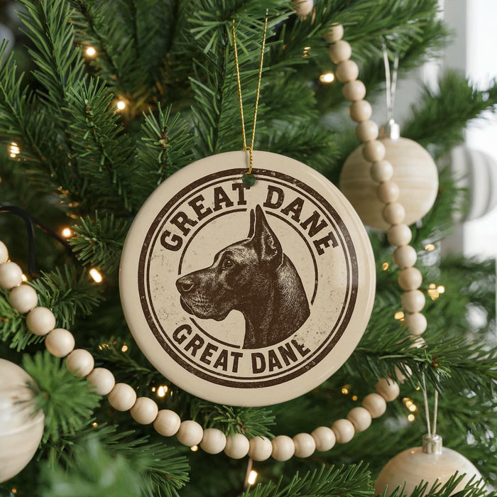 A Christmas tree decorated with ornaments, including a circular ornament with a Great Dane's head and the text "Great Dane" and "Great Dane" written around it.