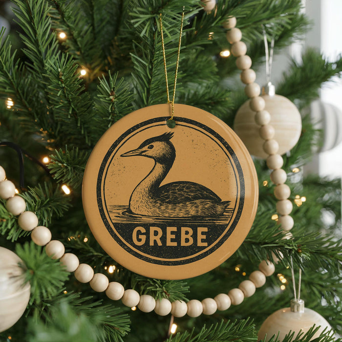 A Christmas tree decorated with ornaments, including a circular ornament with a duck and the word "GREBE" written on it.
