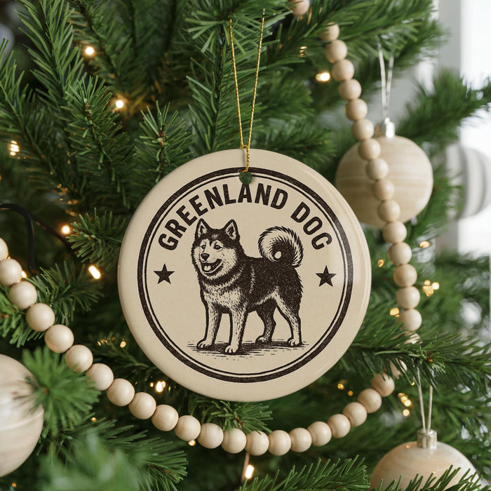 A Christmas tree decorated with ornaments, including a circular ornament with a graphic of a husky dog and the text "GREENLAND DOG".