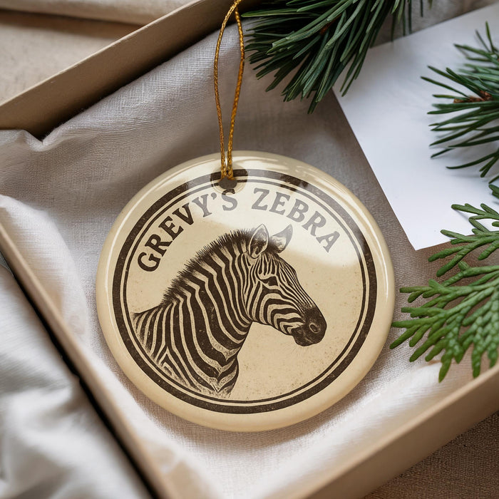 A circular ornament with a zebra's head image and the text "GREVY'S ZEBRA" is displayed in a box, surrounded by pine branches.