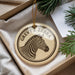 A circular ornament with a zebra's head image and the text "GREVY'S ZEBRA" is displayed in a box, surrounded by pine branches.