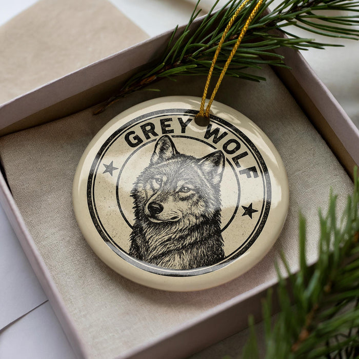 A circular ornament featuring a black and white illustration of a wolf's face, with the text "GREY WOLF" prominently displayed.