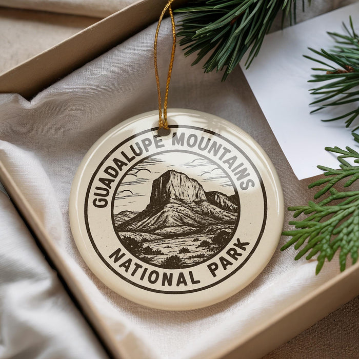 A circular ornament with the text "GUADALUPE MOUNTAINS NATIONAL PARK" printed on it, hanging from a string.