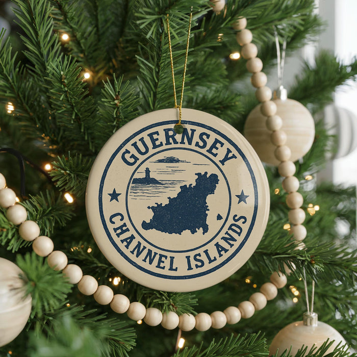 A Christmas tree decorated with ornaments, including a circular ornament with the text "GUERNSEY CHANNEL ISLANDS" and a lighthouse icon.