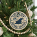 A Christmas tree decorated with ornaments, including a circular ornament with the text "GUERNSEY CHANNEL ISLANDS" and a lighthouse icon.
