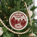 A Christmas tree decorated with ornaments, including a circular ornament with a red and white design that says "GUILIN CHINA" and a boat illustration.