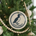 A Christmas tree decorated with ornaments, including a circular ornament with a bird image and the word "GUILLLEMOT" written on it.