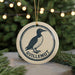 A circular ornament featuring a black and white illustration of a bird, with the text "GUILLLEMOT" prominently displayed.