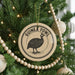 A Christmas tree decorated with ornaments, including a circular ornament with a graphic of a bird and the text "GUINEA FOWL" on it.
