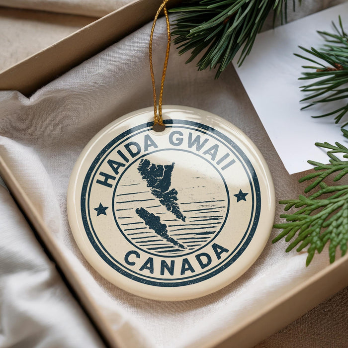 A circular ornament with the text "HAIDA GWALL CANADA" printed on it, hanging from a string.