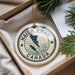 A circular ornament with the text "HAIDA GWALL CANADA" printed on it, hanging from a string.