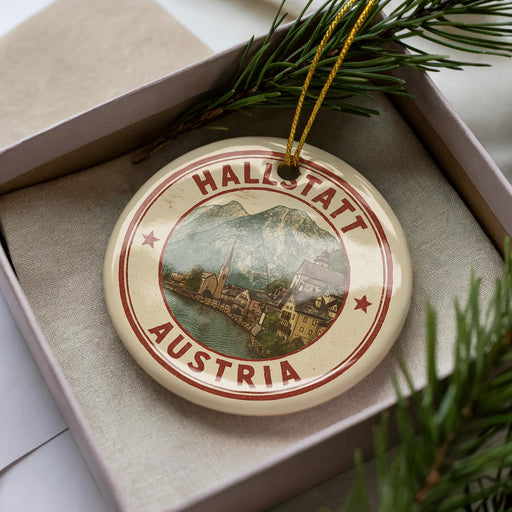 A circular ornament with the text "HALLSTATT AUSTRIA" and an illustration of a town, surrounded by greenery.