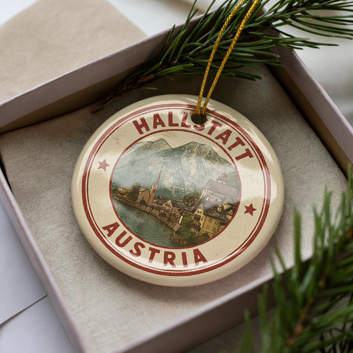 A circular ornament with the text "HALLSTATT AUSTRIA" and an illustration of a town, surrounded by greenery.