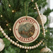 A circular ornament on a Christmas tree, featuring a scenic image of Hallstatt Austria with a mountain backdrop.