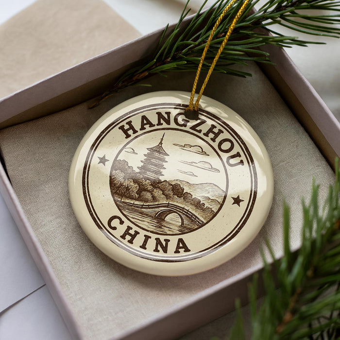 A circular ornament with the text "HANGSHOU CHINA" printed on it, surrounded by a decorative border and a small illustration of a pagoda.