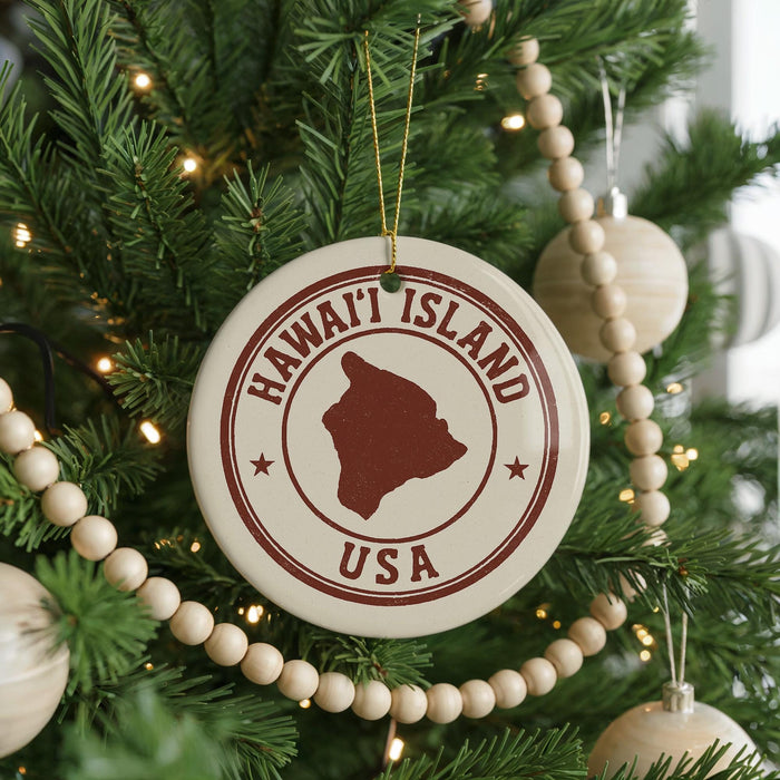A Christmas tree decorated with ornaments, including a circular ornament with the text "HAWAII'I ISLAND USA" and a wooden bead decoration.