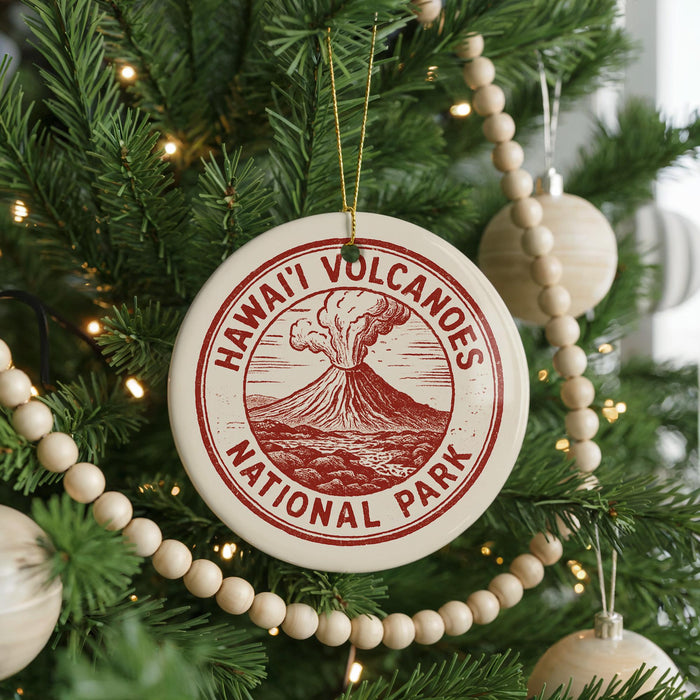 A Christmas tree decorated with ornaments, including a circular ornament with the text "HAWAII'I VOLCANOES NATIONAL PARK" and a wooden bead decoration.