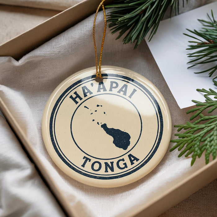 A circular ornament with the text "HA'APAI TONGA" printed on it, surrounded by pine branches.