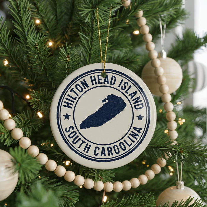 A Christmas tree decorated with ornaments, including a circular ornament with the text "Hilton Head Island, South Carolina" and a silhouette of a boat.