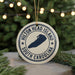 A white ornament with a blue design, featuring the text "Hilton Head Island South Carolina" and a map of the island, is displayed on a Christmas tree with twinkling lights in the background.