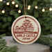 A circular ornament with a red and white design featuring a castle, surrounded by Christmas lights and greenery.
