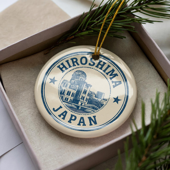 A circular ornament with the text "HIROSHIMA JAPAN" printed on it, surrounded by a decorative border and a small illustration of a building.