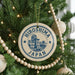 A circular ornament on a Christmas tree, featuring the text "HIrosawa Japan" and an illustration of a building.