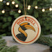 A circular ornament with a hornbill illustration and the word "HORNBILL" written on it, hanging from a string.