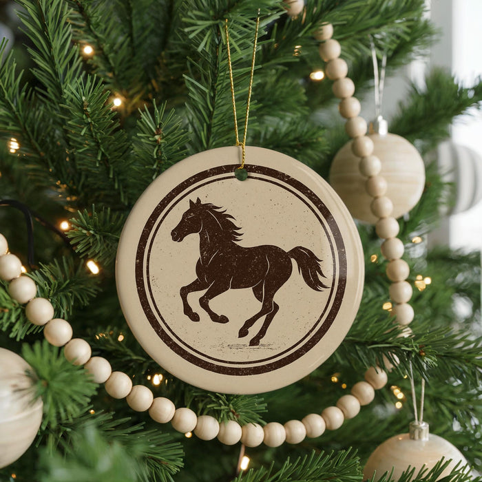 A Christmas tree decorated with ornaments, including a circular ornament featuring a horse silhouette.