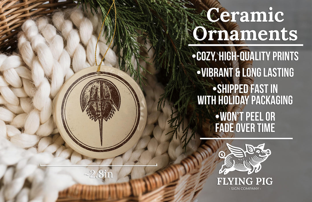 a ceramic ornament hanging from a wicker basket, with a pine branch and greenery in the background.