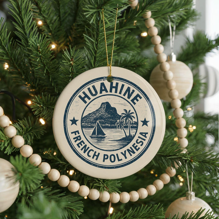 A Christmas tree decorated with ornaments, including a circular ornament with the text "HUAHINE FRENCH POLYNESIA" and a sailboat illustration.