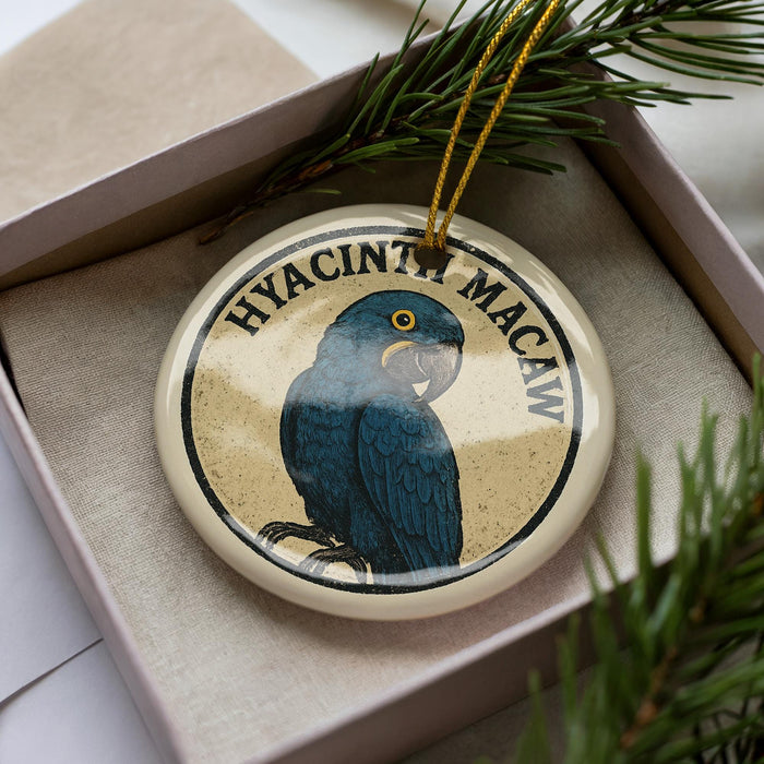 A ceramic ornament in a box, featuring a blue parrot with a yellow beak.