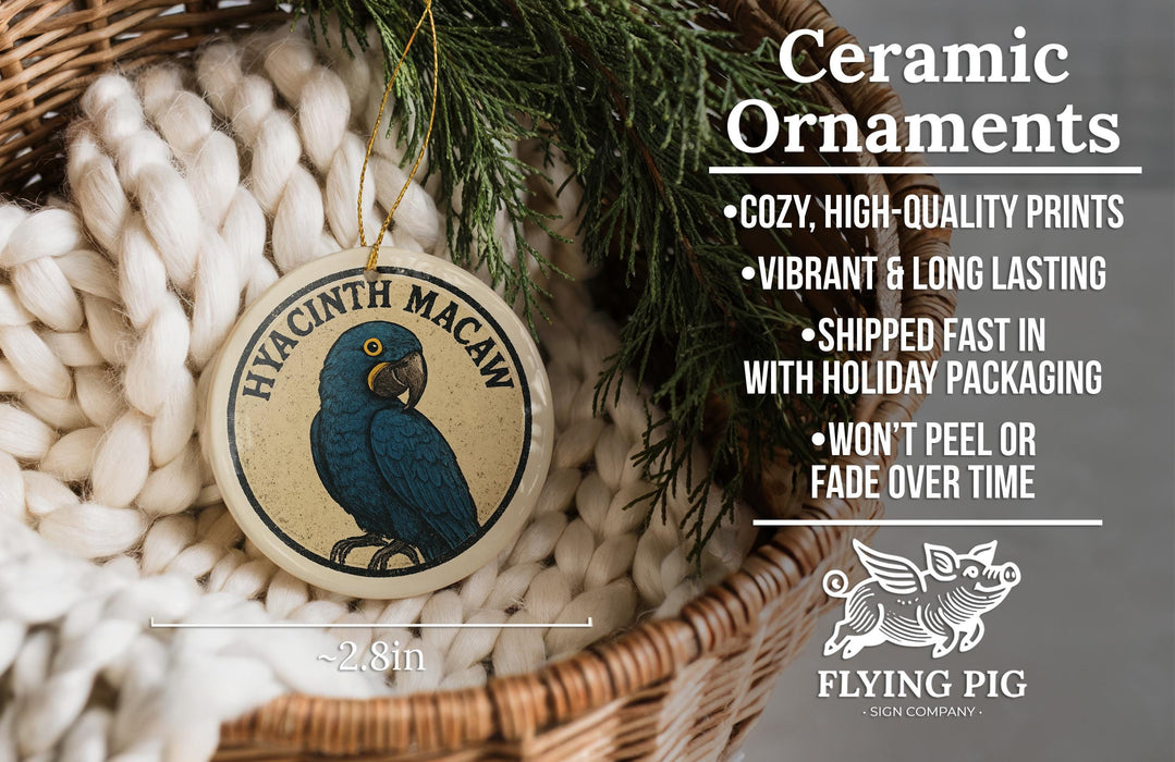Ceramic ornaments, featuring a blue parrot and text, are displayed in a basket with greenery.