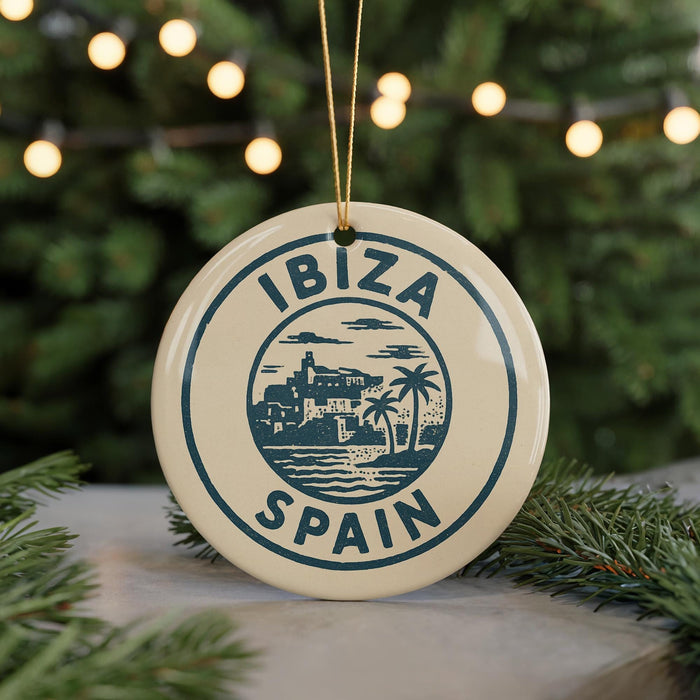 A circular ornament with the text "IBAZ" and "SPAIN" printed on it, surrounded by a decorative border and a palm tree illustration.