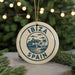 A circular ornament with the text "IBAZ" and "SPAIN" printed on it, surrounded by a decorative border and a palm tree illustration.