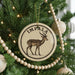A Christmas tree decorated with ornaments, including a circular ornament with an illustration of a gazelle and the word "IMPA" on it.