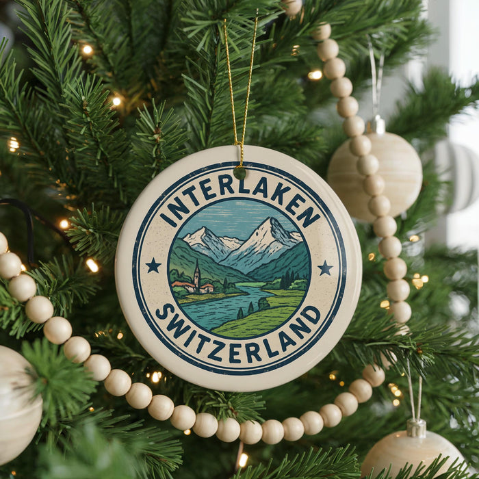 A Christmas tree decorated with ornaments, including a circular ornament with the text "INTERLAKEN SWITZERLAND" and a mountain landscape.