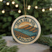 A circular ornament with the text "ISLA DEL SOL BOLIVIA" and an illustration of a mountainous landscape with a small boat on the water.