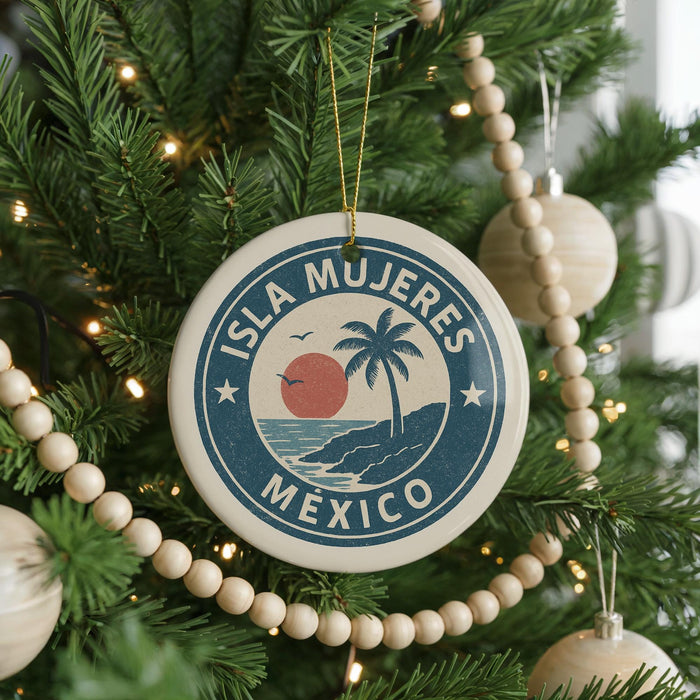 A Christmas tree decorated with ornaments, including a circular ornament with the text "ISLA MUEJERES MEXICO" and a palm tree design.