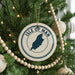 A Christmas tree decorated with ornaments, including a circular ornament with the text "ISLE OF MAN" and a silhouette of the island of Jersey.