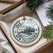 A decorative ornament with the text "ISLE OF PINES NEW CALEDONIA" printed on it, hanging from a string.