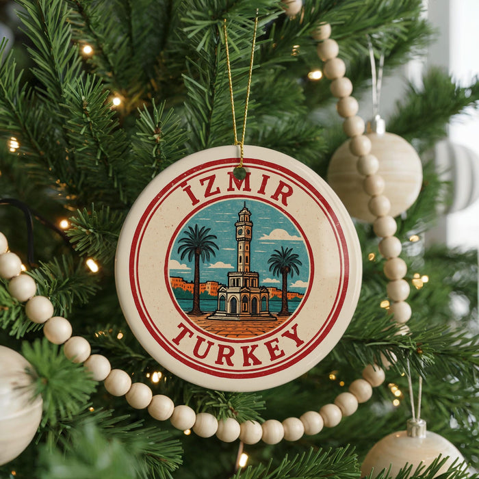 A circular ornament on a Christmas tree, featuring a red and white border and a picture of a tower surrounded by palm trees.
