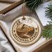 A round ornament with the text "JASPER NATIONAL PARK CANADA" printed on it, surrounded by pine branches and a white paper.