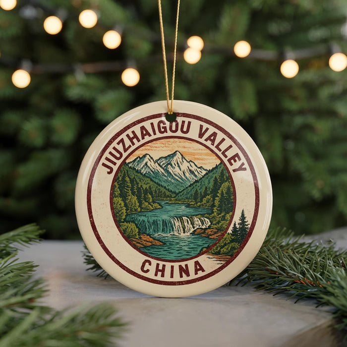 A round ornament with a mountain landscape and waterfall design, featuring the text "JIZUHAI GOU VALLEY CHINA" on it.